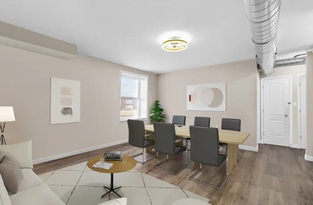 Concept rendering, virtually staged: the large front office at 7187 Upstairs shown with a conference table, lounge seating and the door to the private entrance